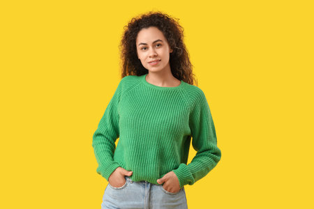 Young African-American woman on yellow backgroundの写真素材