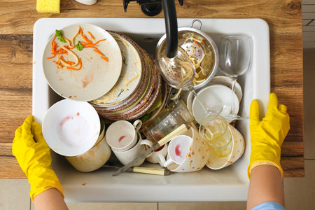 Woman washing dirty dishes in sinkの写真素材