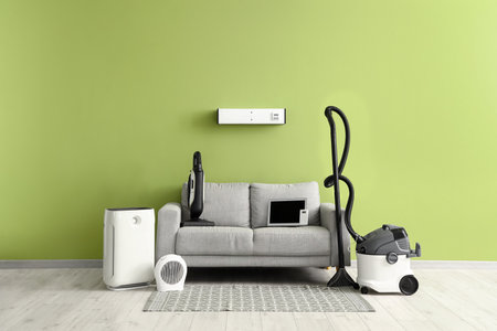 Couch with modern household appliances near light green wall in roomの写真素材