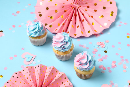 Delicious cupcakes with decorations on blue background. Gender reveal party conceptの写真素材