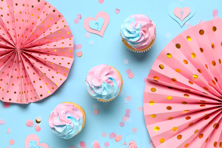 Delicious cupcakes with decorations on blue background. Gender reveal party conceptの写真素材