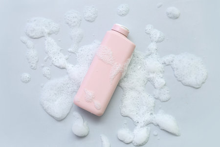 Bottle of cosmetic product with foam on gray backgroundの写真素材