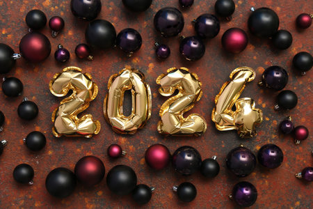 Composition with figure 2024 made of foil balloons and Christmas balls on brown background
