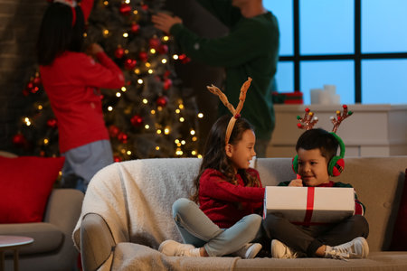 Happy little children with gift at home on Christmas Eveの写真素材