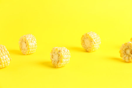 Cut fresh corn cob on yellow backgroundの写真素材