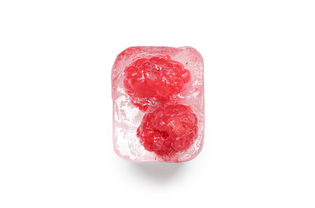 Frozen raspberries in ice cube on white backgroundの写真素材