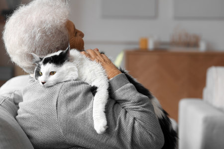 Senior woman with cute cat resting at homeの写真素材