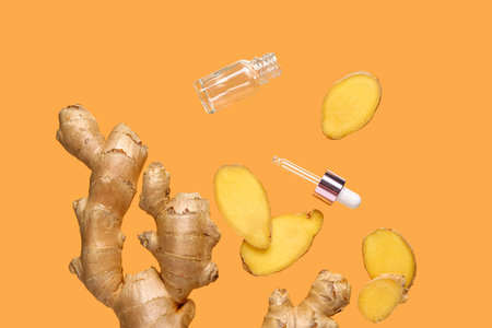 Flying slices of fresh ginger root and cosmetic bottle on orange background
