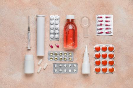 Different pills, syringe and bottles of medicines on pink backgroundの写真素材