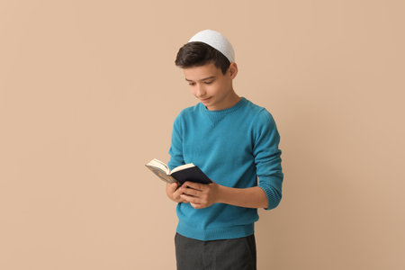 Little Muslim boy with Quran on beige backgroundの写真素材