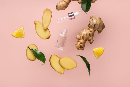 Flying slices of fresh ginger root and cosmetic bottle on pink background
