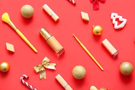 Beautiful makeup products and Christmas decor on red backgroundの写真素材