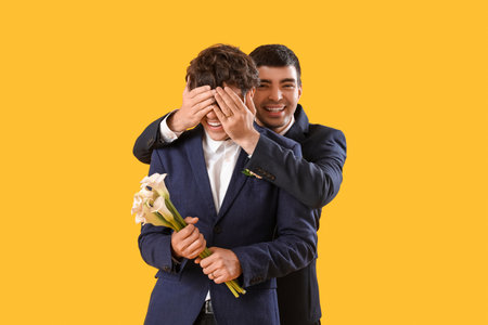 Married gay couple with flowers on yellow backgroundの写真素材