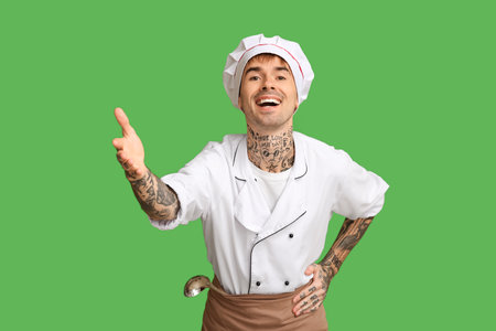 Smiling young chef on green backgroundの写真素材