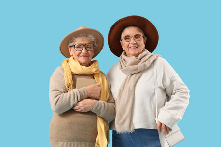 Senior female friends in stylish clothes on blue backgroundの写真素材