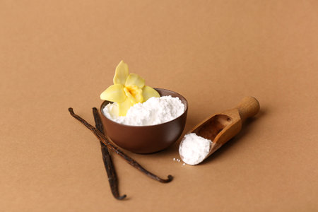 Bowl of vanilla powder, sticks and flower on color backgroundの写真素材