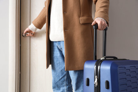 Male tourist with suitcase at door in hotel, closeupの写真素材