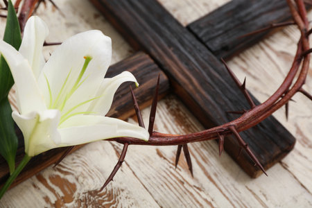 Crown of thorns with white lily and cross on wooden background, closeupの写真素材