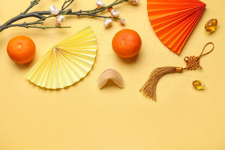 Composition with Chinese symbols, tangerines and sakura branch on color background. New Year celebrationの写真素材