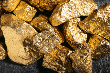 Golden nuggets on dark background, closeup