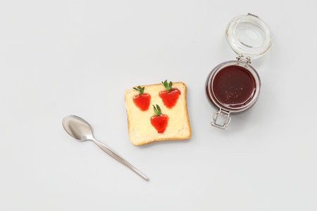 Tasty toast with sweet strawberry jam on gray background