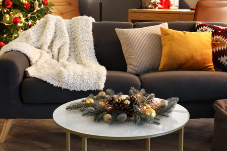 Comfortable sofa and coffee table with Christmas decorations in modern living room