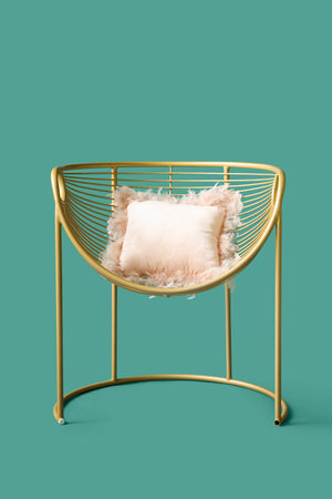 Stylish armchair with cushion on green backgroundの写真素材
