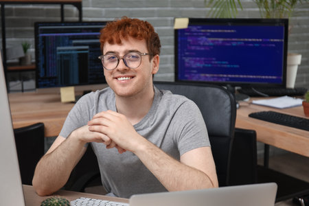 Male programmer working with computer at table in officeの写真素材