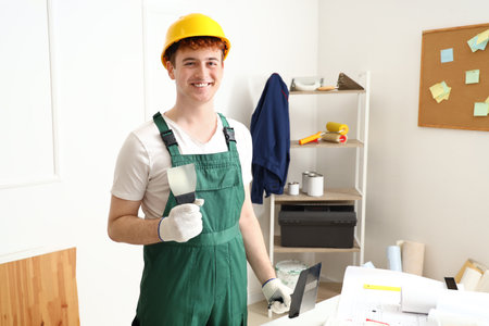 Male decorator with putty knife working in roomの写真素材