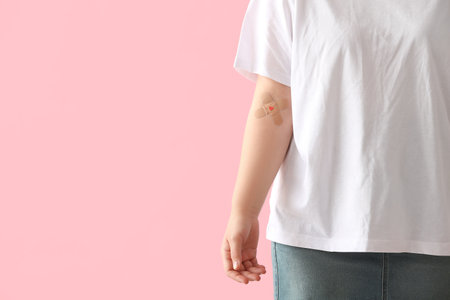Blood donor with applied medical patches on pink backgroundの写真素材