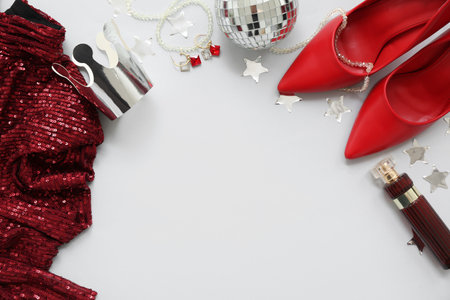 Female prom outfit with crown, disco ball and perfume bottle on white backgroundの写真素材