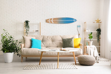 Interior of light living room with white sofa and surfboardの写真素材
