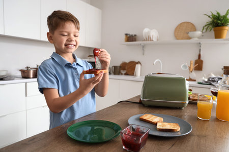 Little boy making toast with jam in kitchenの写真素材