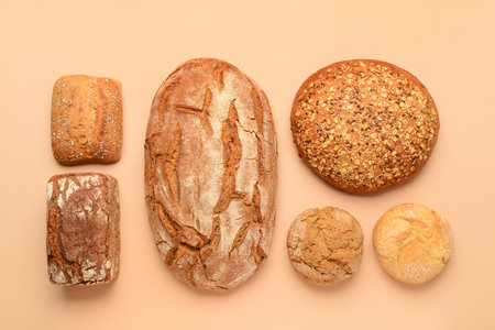 Loaves of fresh bread and buns on beige backgroundの写真素材
