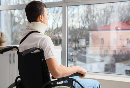 Injured young man in wheelchair after accident at homeの写真素材