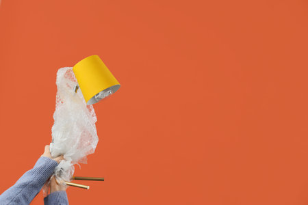 Woman with wrapped lamp on orange background. Moving concept