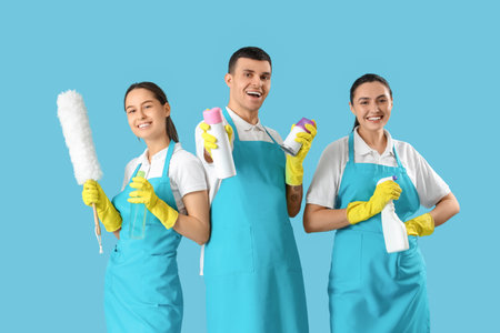 Workers of cleaning service with supplies on blue backgroundの写真素材