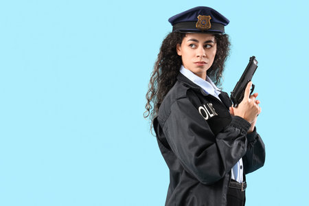 African-American female police officer with gun on blue backgroundの写真素材