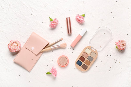 Case for brushes with makeup products, flowers and sequins on white grunge backgroundの写真素材