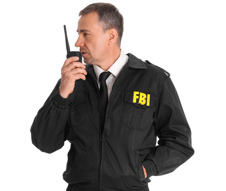 Mature FBI agent with two-way radio on white backgroundの写真素材