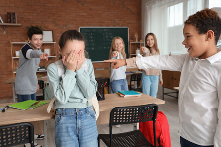 Bullied little girl with her classmates in classroom