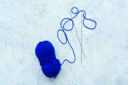 Yarn ball and knitting needles on blue grunge backgroundの写真素材