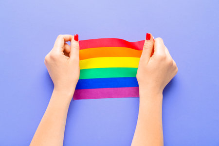 Woman with LGBT flag on lilac backgroundの写真素材