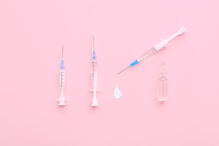 Medical syringes with ampoule on pink backgroundの写真素材