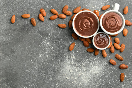 Bowls of tasty melted chocolate with almonds on gray grunge backgroundの写真素材