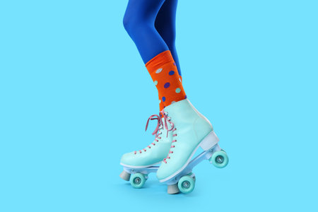 Legs of woman in roller skates on blue background