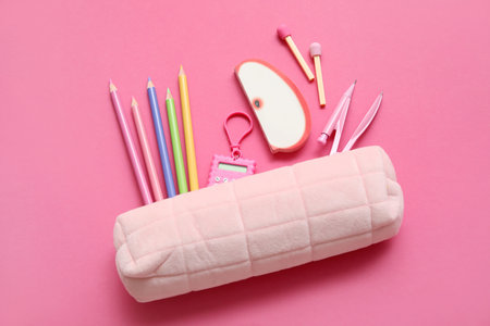 Pencil case with different school stationery on pink backgroundの写真素材