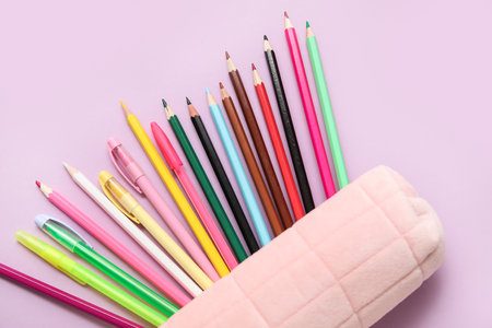 Pencil case with colorful pens and pencils on purple backgroundの写真素材