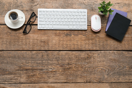 Laptop, cup of coffee and stationery on wooden tableの写真素材