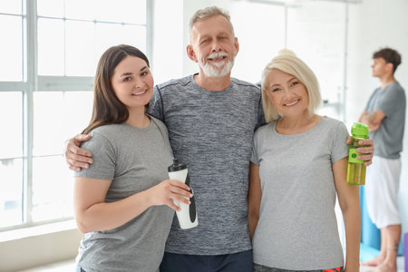 Group of sporty people with bottles of water in gymの写真素材